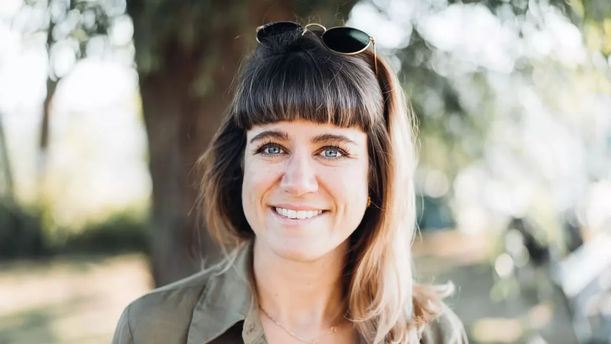 Nadine Gloor ist die Leiterin Marketing und Kommunikation beim Juckerhof. Nadine Gloor vor einer ländlichen Umgebung